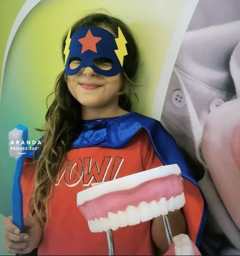 Niña disfrazada de superheroína del cuidado dental