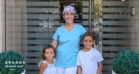 Dra. Isabel Aranda con dos niñas en la entrada de la clínica dental
