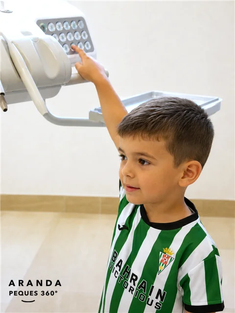 Niño tocando los mandos del sillón dental en Clínica Dental Aranda en Córdoba