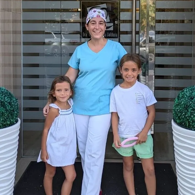 Dentista con dos niñas en la entrada de Clínica Dental Aranda
